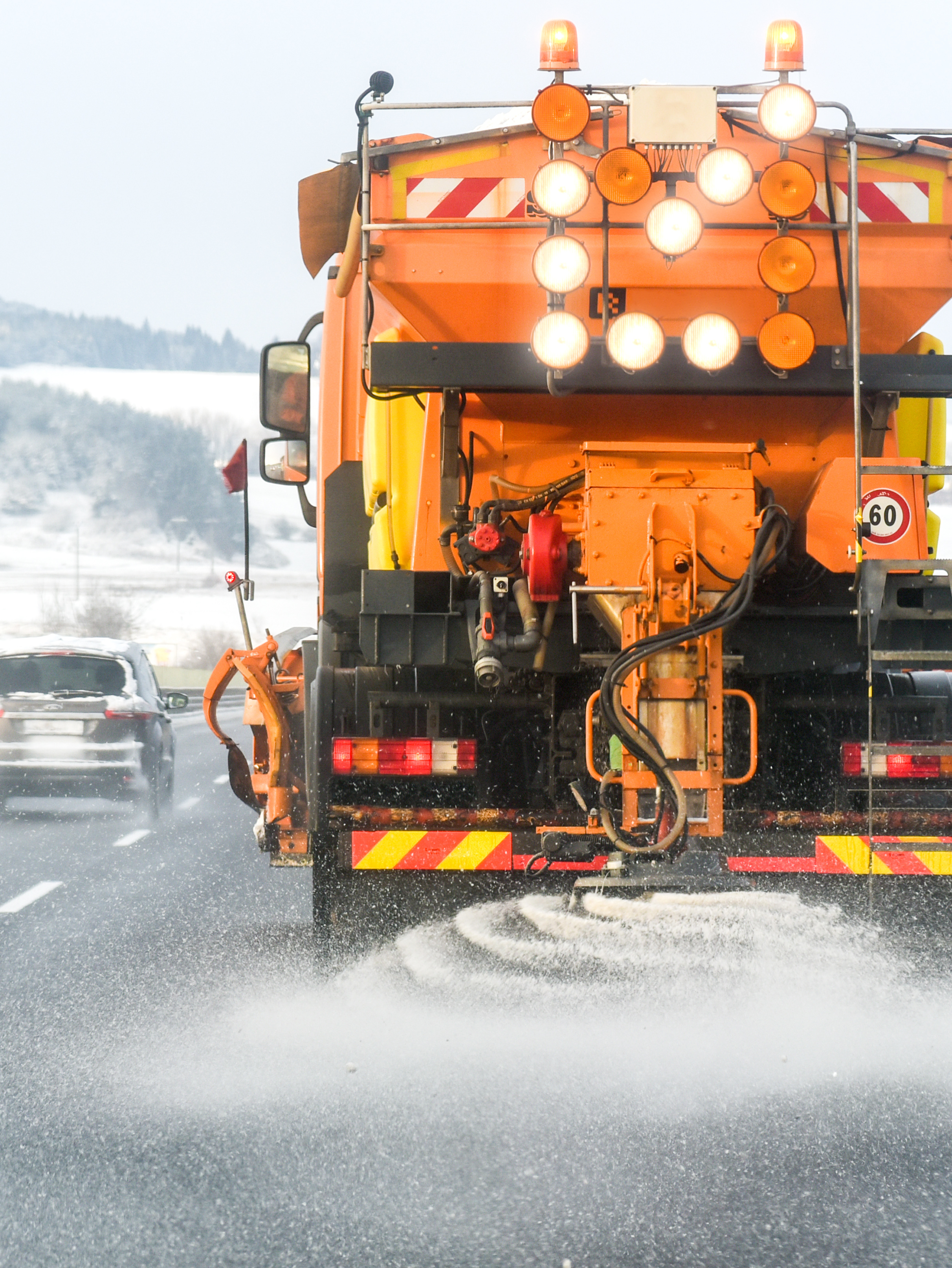A salt truck spreading salt on a winter snowy road